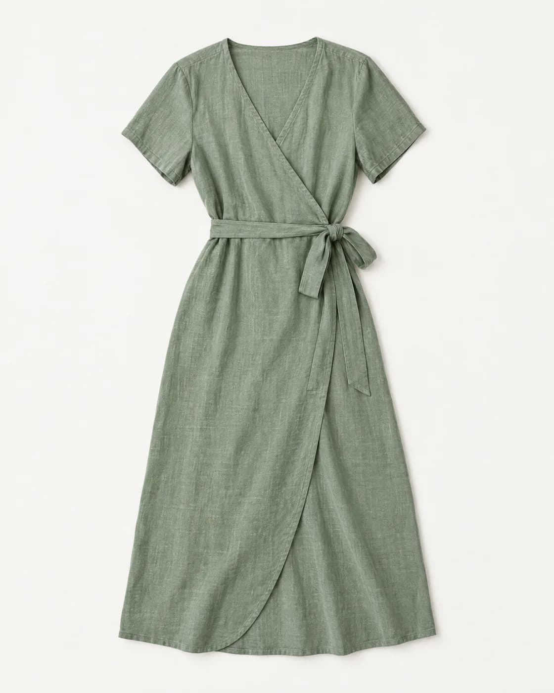Robe portefeuille mi-longue en lin vert sauge, photographiée à plat sur fond blanc cassé