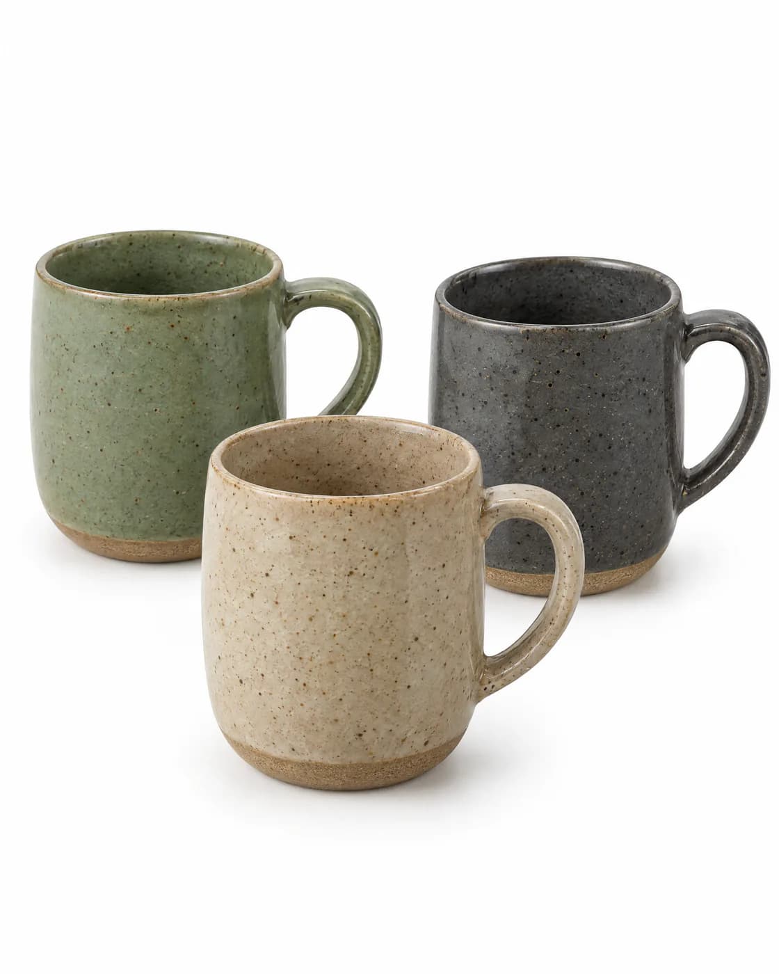 Trois mugs en grès vert sauge, sable et anthracite, photographiés dans la même lumière sur fond blanc